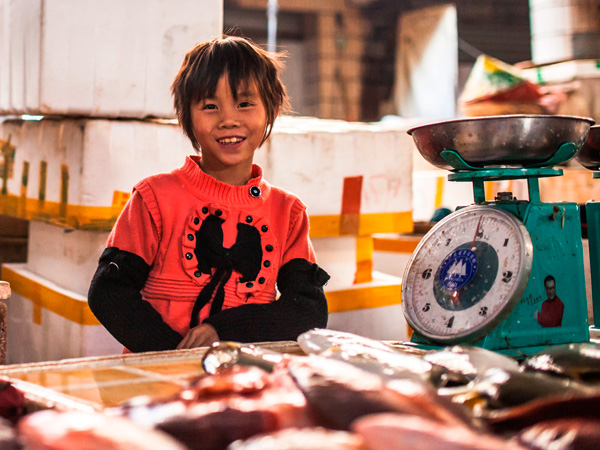 Китайский мальчик торгует на рынке